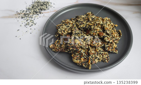 Crispy crackers made from chia, flax, sunflower, and pumpkin seeds, dried 135238399