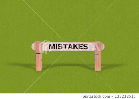 Mistakes symbol. Wooden stick anchored by Clothespins, Cool Green Background. Business and Mistakes concept with copy space Mistakes symbol. Wooden stick anchored by Clothespins, Cool Green Background. Business and Mistakes concept with copy space 135238515