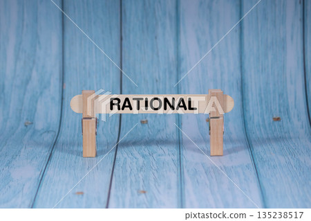 Rational symbol. Wooden stick clamped by Clothespins, vivid blue wooden backdrop. Business and Rational concept with copy space 135238517