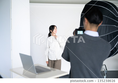 一位女模特兒和一位男攝影師正在指導 135238616