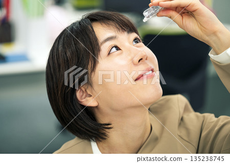 年輕女子在辦公室滴眼藥水 135238745