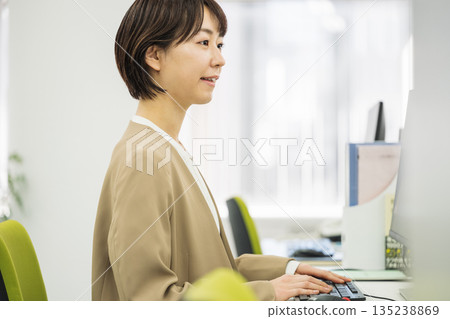 在辦公室做案頭工作的年輕女子 135238869