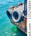 The floating dock is equipped with rubber tires with turquoise water reflecting sunlight. 135238884