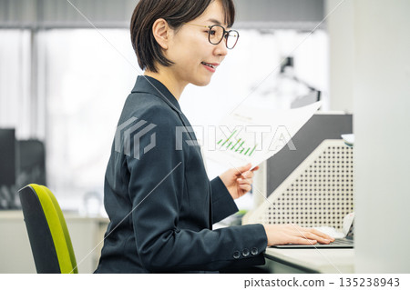 在辦公室做案頭工作的年輕女子 135238943