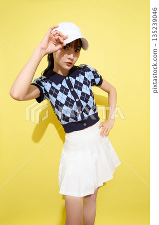 一位年輕女子穿著可愛運動服,背景是淺色的。 一位年輕女子穿著可愛運動服,背景是淺色的。 135239046