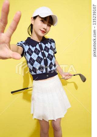 一位年輕女子穿著可愛運動服,背景是淺色的。 一位年輕女子穿著可愛運動服,背景是淺色的。 135239107
