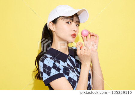 一位年輕女子穿著可愛運動服,背景是淺色的。 一位年輕女子穿著可愛運動服,背景是淺色的。 135239110