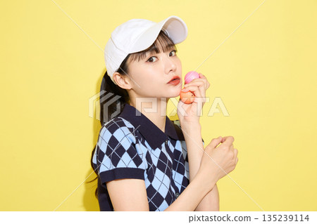 一位年輕女子穿著可愛運動服,背景是淺色的。 一位年輕女子穿著可愛運動服,背景是淺色的。 135239114