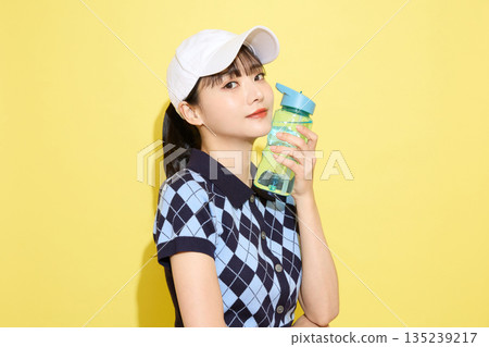 一位年輕女子穿著可愛運動服，背景是淺色的。 135239217