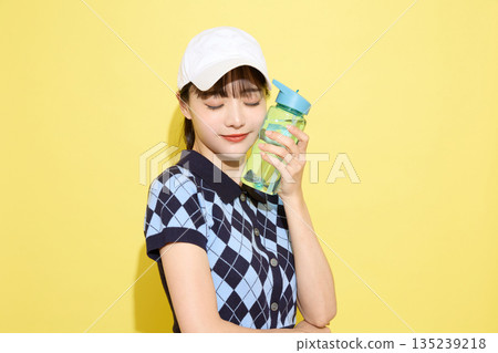 一位年輕女子穿著可愛運動服，背景是淺色的。 135239218