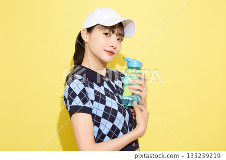 一位年輕女子穿著可愛運動服，背景是淺色的。 135239219