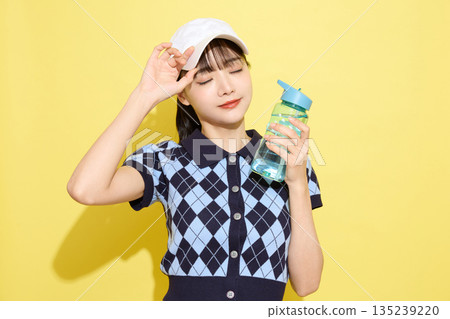 一位年輕女子穿著可愛運動服，背景是淺色的。 135239220