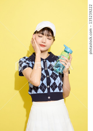 一位年輕女子穿著可愛運動服，背景是淺色的。 135239222
