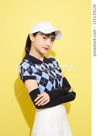 一位年輕女子穿著可愛運動服,背景是淺色的。 一位年輕女子穿著可愛運動服,背景是淺色的。 135239226
