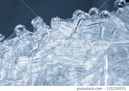 Close up scene of group of preform shape of PET bottle products in the light blue scene. Close up scene of group of preform shape of PET bottle products in the light blue scene. 135239555