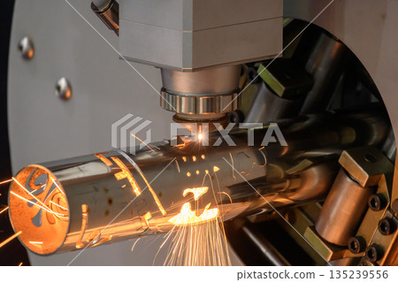 Close up scene the fiber laser cutting machine cut the stainless steel tube control by CNC program. 135239556