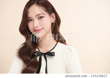 A beautiful young Asian woman with clean, fresh skin against a beige background. Skincare, facial treatment, cosmetology, beauty, and spa. An elegant portrait of an Asian woman. A beautiful young Asian woman with clean, fresh skin against a beige background. Skincare, facial treatment, cosmetology, beauty, and spa. An elegant portrait of an Asian woman. 135239617