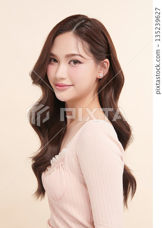 A beautiful young Asian woman with clean, fresh skin against a beige background. Skincare, facial treatment, cosmetology, beauty, and spa. An elegant portrait of an Asian woman. A beautiful young Asian woman with clean, fresh skin against a beige background. Skincare, facial treatment, cosmetology, beauty, and spa. An elegant portrait of an Asian woman. 135239627
