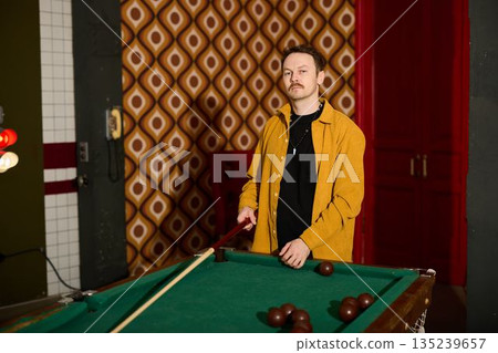 Fashionable billiards coach displays impressive shot control 135239657
