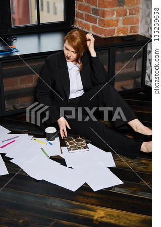 Tired female worker surrounded by documents during late night crisis 135239658