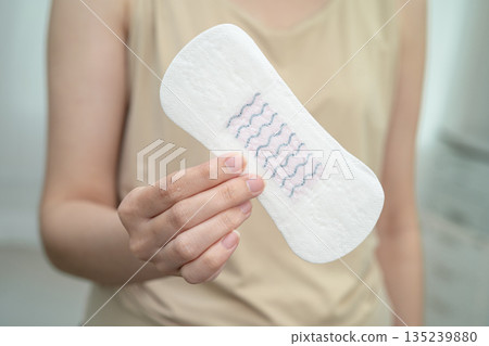 Asian woman holding sanitary napkin pad for hygiene menstrual period cycle protection. 135239880