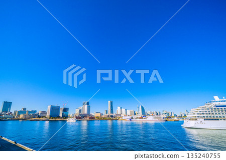 Yokohama cityscape in Japan, with Mount Fuji (back center) and Asuka III competing (Nippon Maru at Shinko Pier). Kannai Tower on the left... 135240755