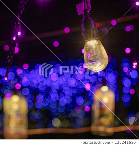 A shining light bulb against a blurred background A shining light bulb against a blurred background 135241650