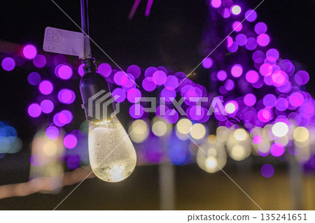 A shining light bulb against a blurred background A shining light bulb against a blurred background 135241651