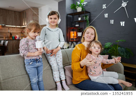 Mother and her three daughters have a karaoke party Mother and her three daughters have a karaoke party 135241955