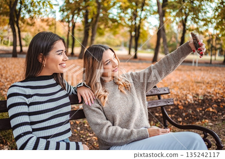 Capturing moments of friendship amidst autumn leaves in a peaceful park Capturing moments of friendship amidst autumn leaves in a peaceful park 135242117