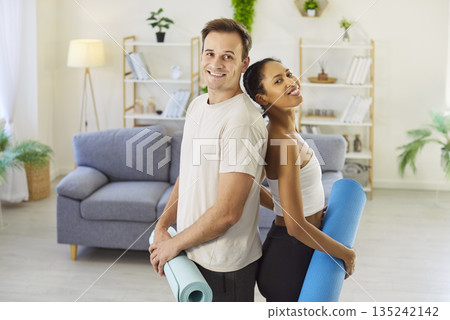 Active couple training together at home, young people standing with smiles Active couple training together at home, young people standing with smiles 135242142