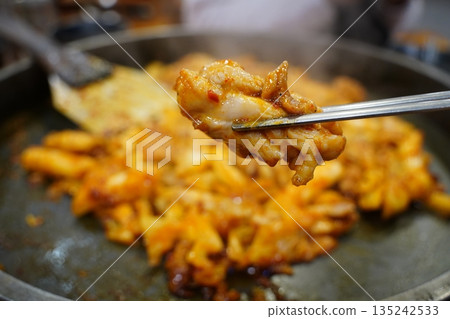 Sizzling Korean spicy stir fried chicken (Dak-galbi) with vegetables on a hot iron plate 135242533