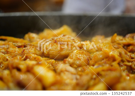 Sizzling Korean spicy stir fried chicken (Dak-galbi) with vegetables on a hot iron plate Sizzling Korean spicy stir fried chicken (Dak-galbi) with vegetables on a hot iron plate 135242537