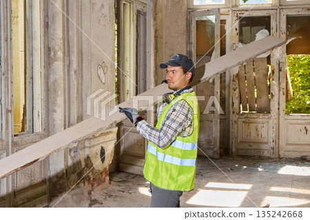Experienced craftsperson carefully positions support beams Experienced craftsperson carefully positions support beams 135242668