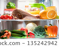 An open refrigerator door. A fridge full of healthy and wholesome food. 135242942