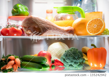 An open refrigerator door. A fridge full of healthy and wholesome food. An open refrigerator door. A fridge full of healthy and wholesome food. 135242942