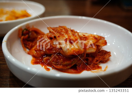 Spicy Korean kimchi in a white bowl, a traditional fermented side dish 135243351