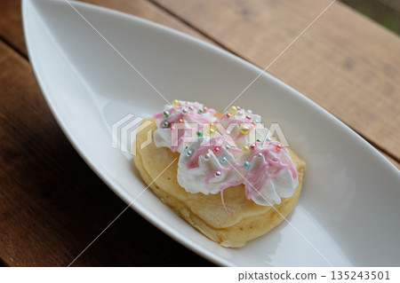 Homemade pancakes topped with fresh cream and sprinkles Homemade pancakes topped with fresh cream and sprinkles 135243501
