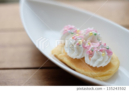 Homemade pancakes topped with fresh cream and sprinkles Homemade pancakes topped with fresh cream and sprinkles 135243502