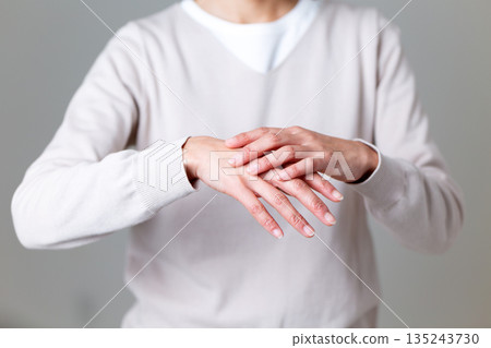Middle-aged woman suffering from dry hands 135243730