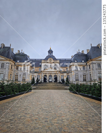 Maincy, France - December 11, 2025: Grand facade of Chateau de Vaux-le-Vicomte with cobblestone courtyard. Beautiful Baroque architecture decorated with small evergreen trees for the winter holidays Maincy, France - December 11, 2025: Grand facade of Chateau de Vaux-le-Vicomte with cobblestone courtyard. Beautiful Baroque architecture decorated with small evergreen trees for the winter holidays 135243775