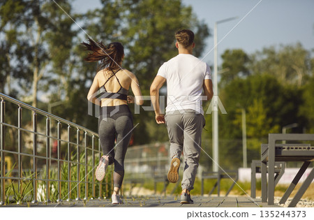 Man And Woman Running In City Park 135244373