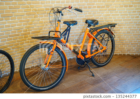 Colorful bicycles placed in a room with a wooden floor 135244377