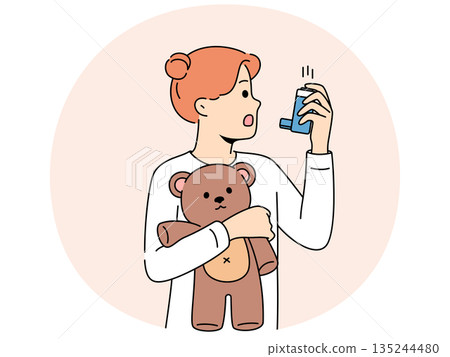 Little girl with asthma uses inhaler to restore breathing during attack and holds teddy bear 135244480