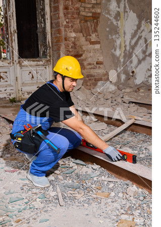 Skilled laborer meticulously positioning metal rail during renovation 135244602