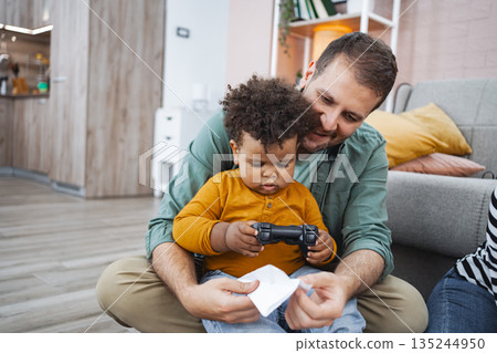 Family bonding over video games in a cozy living room 135244950