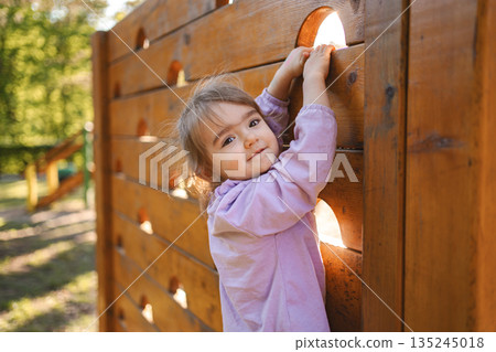 Little cute girl is climbing on the playground 135245018