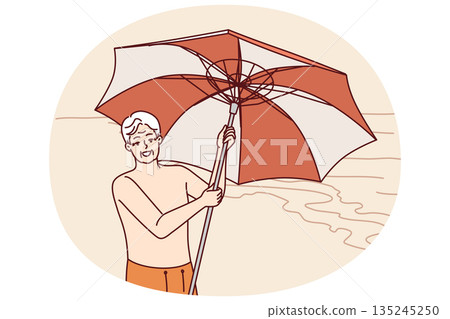 Elderly man stands on beach and holds umbrella to protect from sun during trip to tropical resort Elderly man stands on beach and holds umbrella to protect from sun during trip to tropical resort 135245250