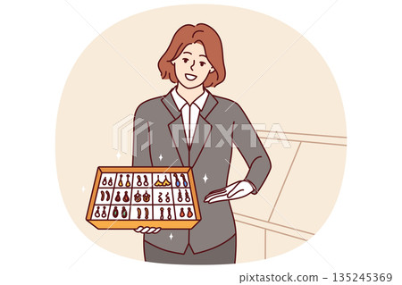 Woman jewelry store clerk demonstrates collection of earrings with precious stones, offering to buy 135245369