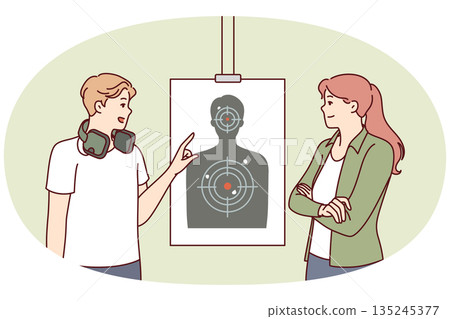 Man teaches woman to shoot at targets with rifle range of firearms for admission to police academy 135245377